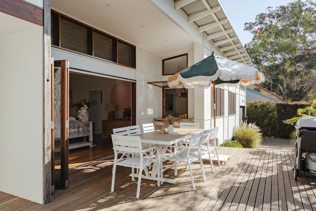 a patio with a table and chairs and an umbrella at Oyster Catcher Huskisson in Huskisson