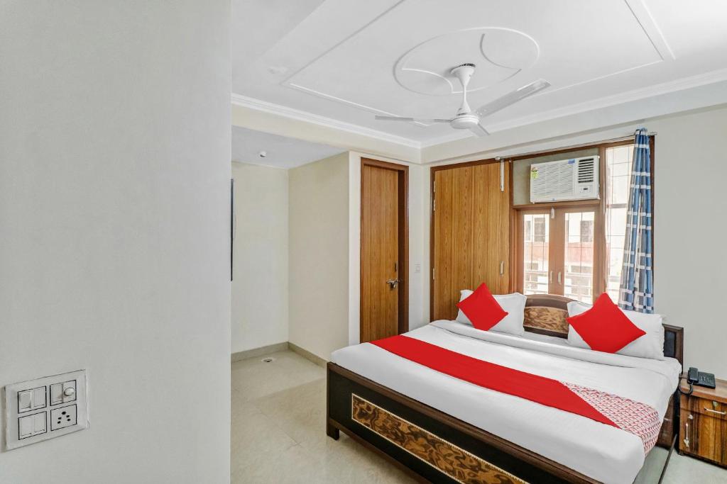 a bedroom with a large bed with red pillows at Hotel O South Plaza in New Delhi