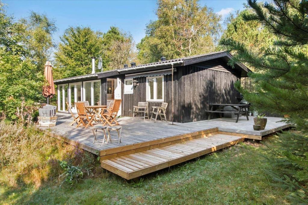 a wooden deck with a table and chairs on a cabin at TV1308-Albaek-Zefyrvej-4 in Ålbæk