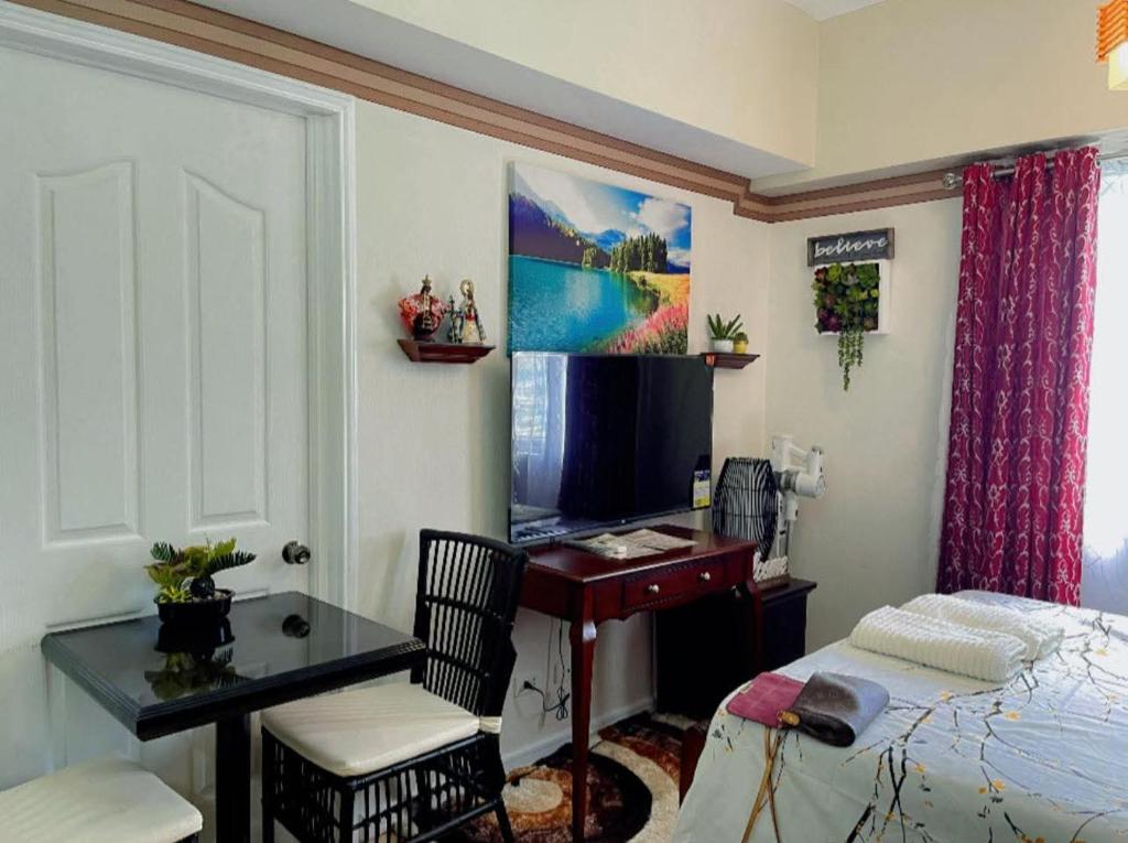 a bedroom with a bed and a desk with a computer at Sunvida Tower staycation unit 2503-2504 in Cebu City