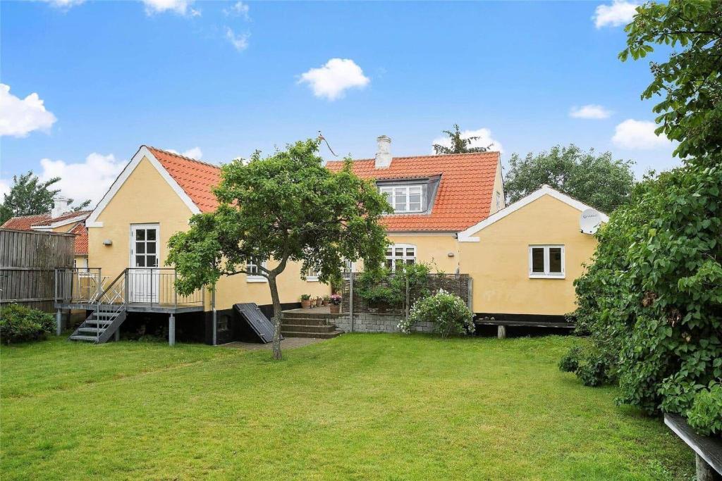 a yellow house with a tree in the yard at TV1405-Skagen-Skomagergangen-5 in Skagen