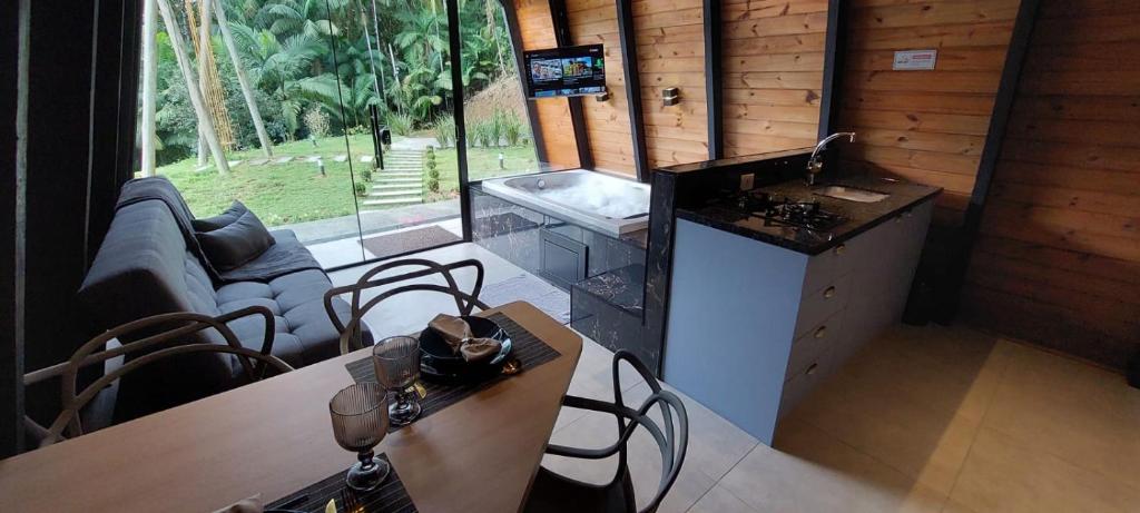 a room with a kitchen and a table and chairs at Chalé Valentina com Hidro - oktoberfest in Blumenau