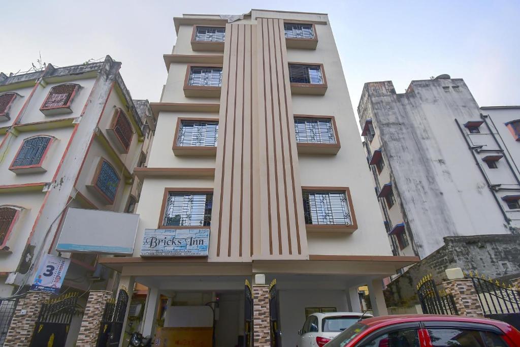 a tall building with a column in front of it at Collection O Bricks Inn Hazra Road Near Birla Mandir in Ballygunge