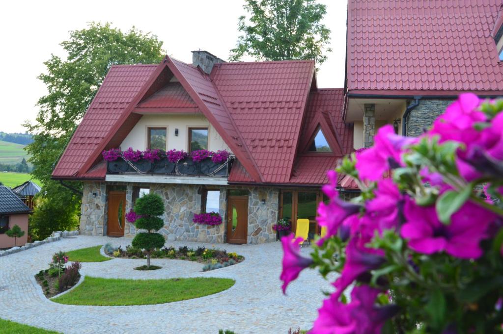 a house with pink flowers in front of it at Ostrysz in Dzianisz