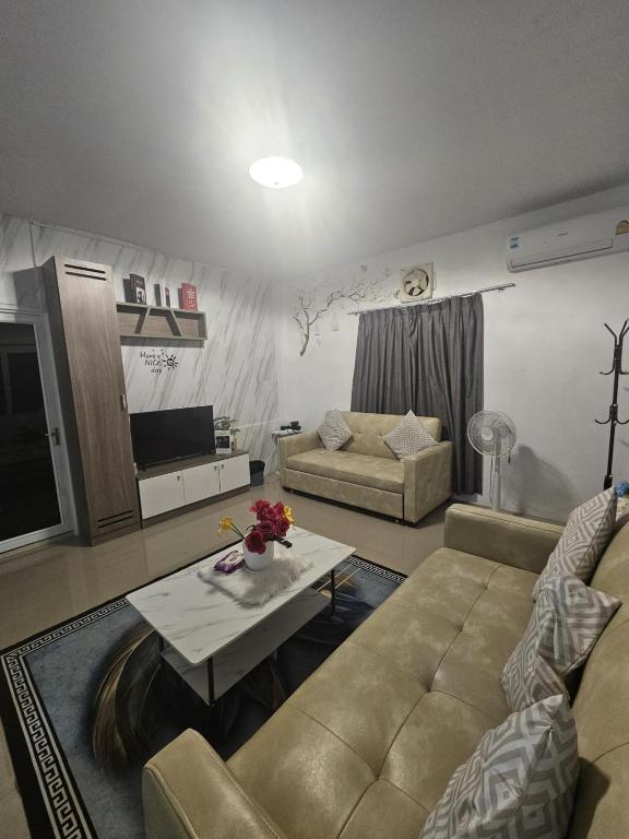a living room with a couch and a table at บ้านพักอู้ฟู่ in Na Jomtien