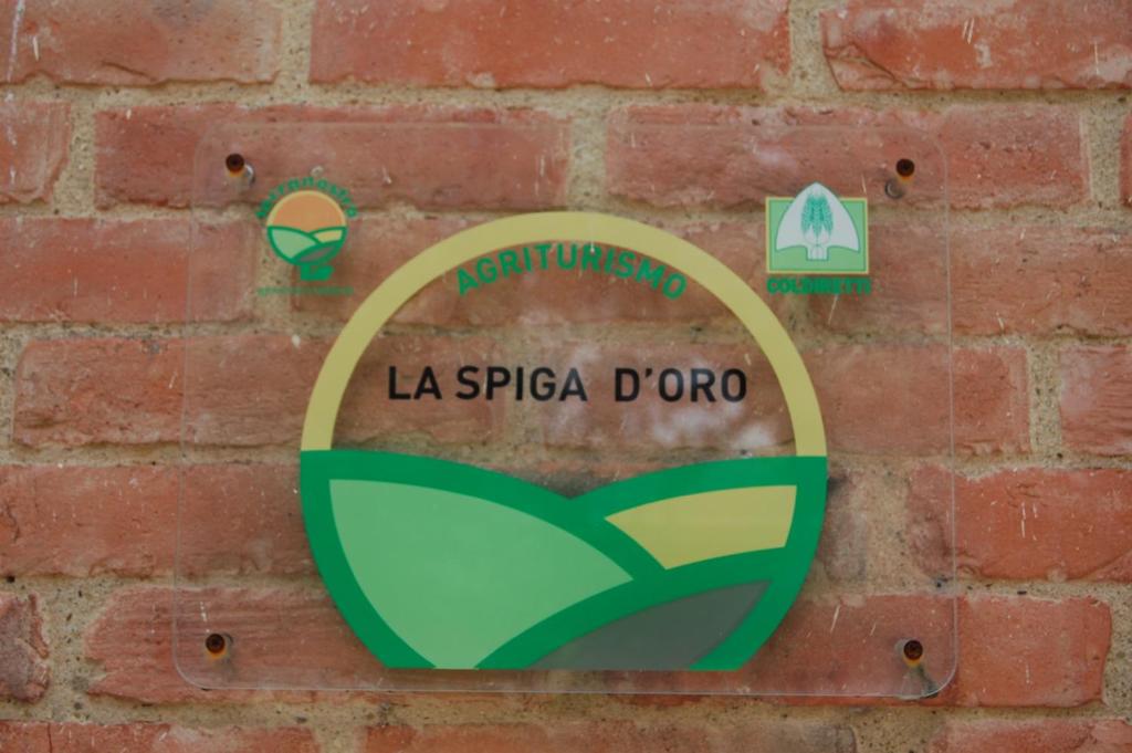 una señal de la spiga dora en una pared de ladrillo en La Spiga D'Oro, en Foiano della Chiana