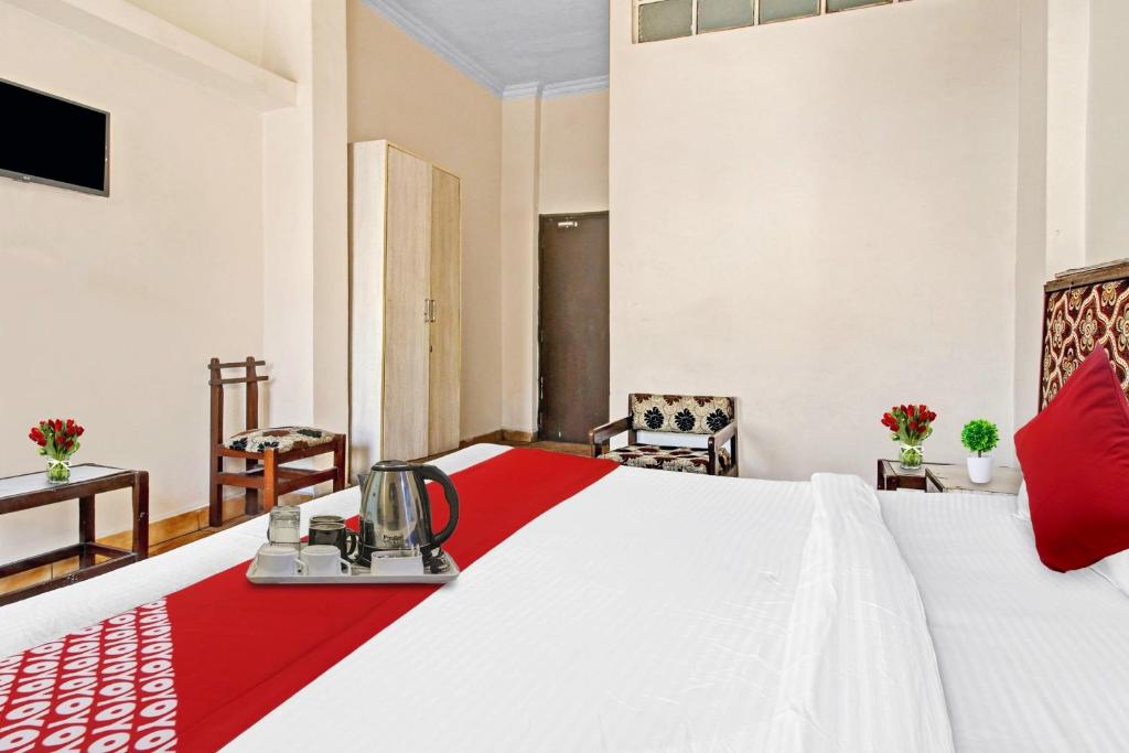 博帕尔Hotel O Amulya Shri的酒店房间有一张床，上面铺着红毯子