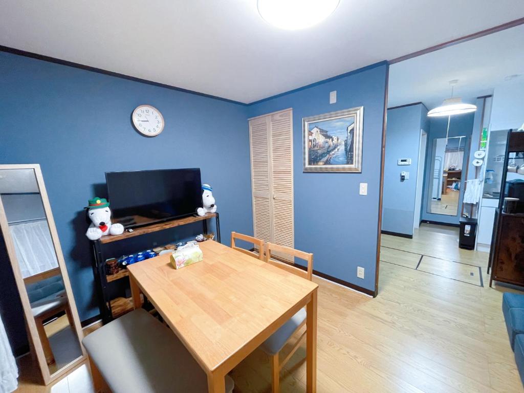 a dining room with a table and a clock on the wall at Mie's House Skytree 美英軒 in Tokyo