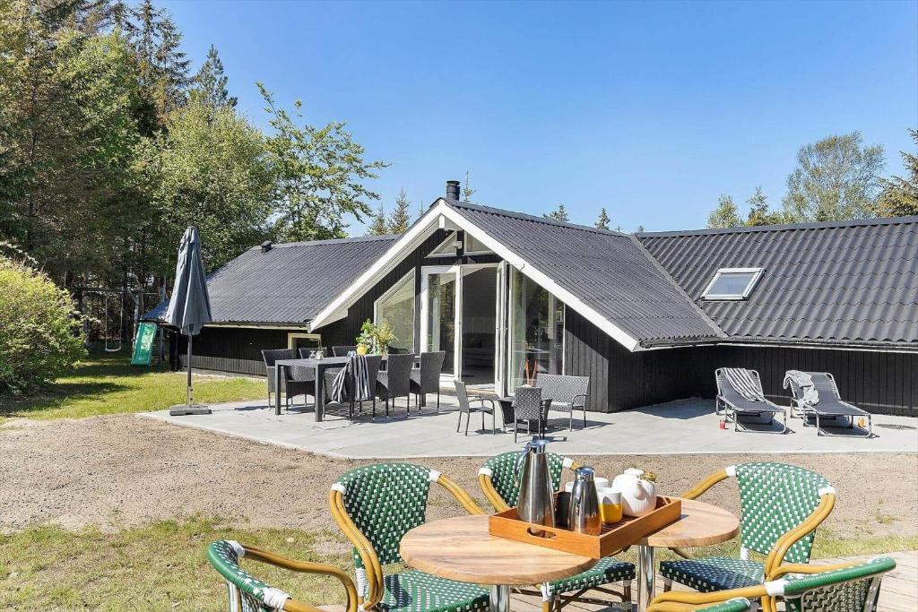 eine Terrasse mit Tisch und Stühlen vor einem Haus in der Unterkunft TV1661 Jerup - Blåbærvej 5 in Jerup