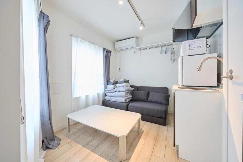 a small living room with a couch and a refrigerator at 12 とりっぱーずホテル高田馬場 in Tokyo