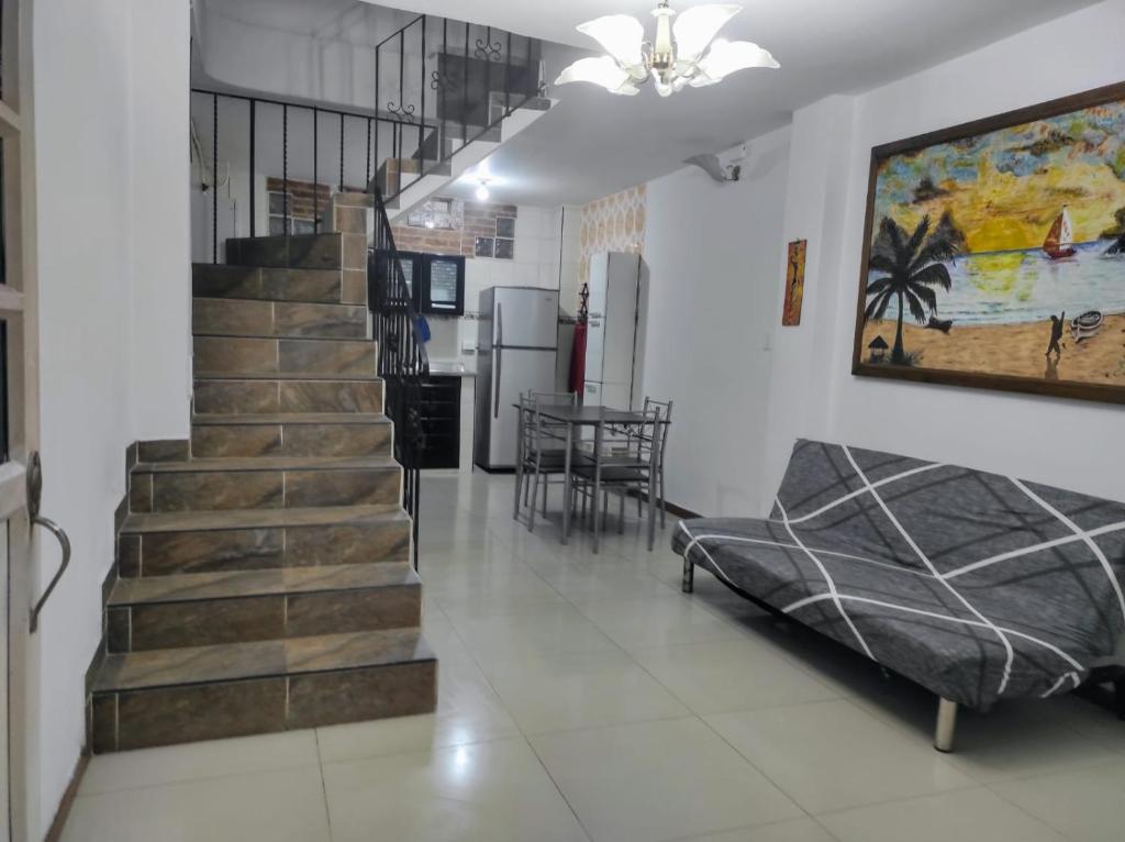 Una sala de estar con escalera y un comedor. en Casita entre árboles, casa de huéspedes céntrica y cómoda en San Fernando, Cali, en Cali