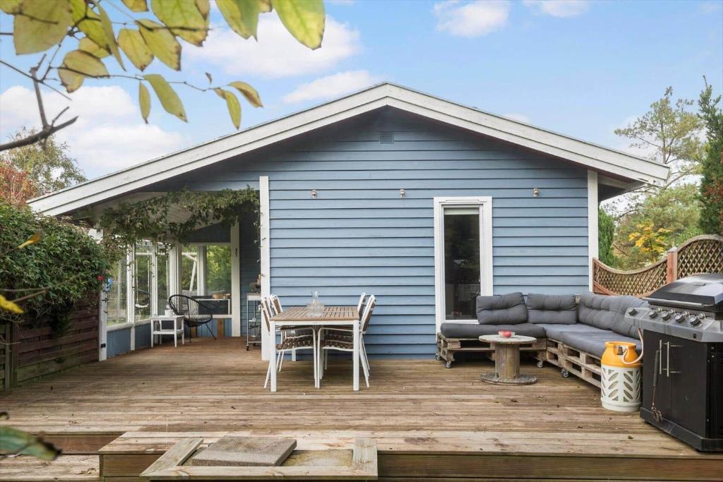 a blue house with a deck with a couch at SL325-Slagelse-Ringduevej-6 in Slagelse