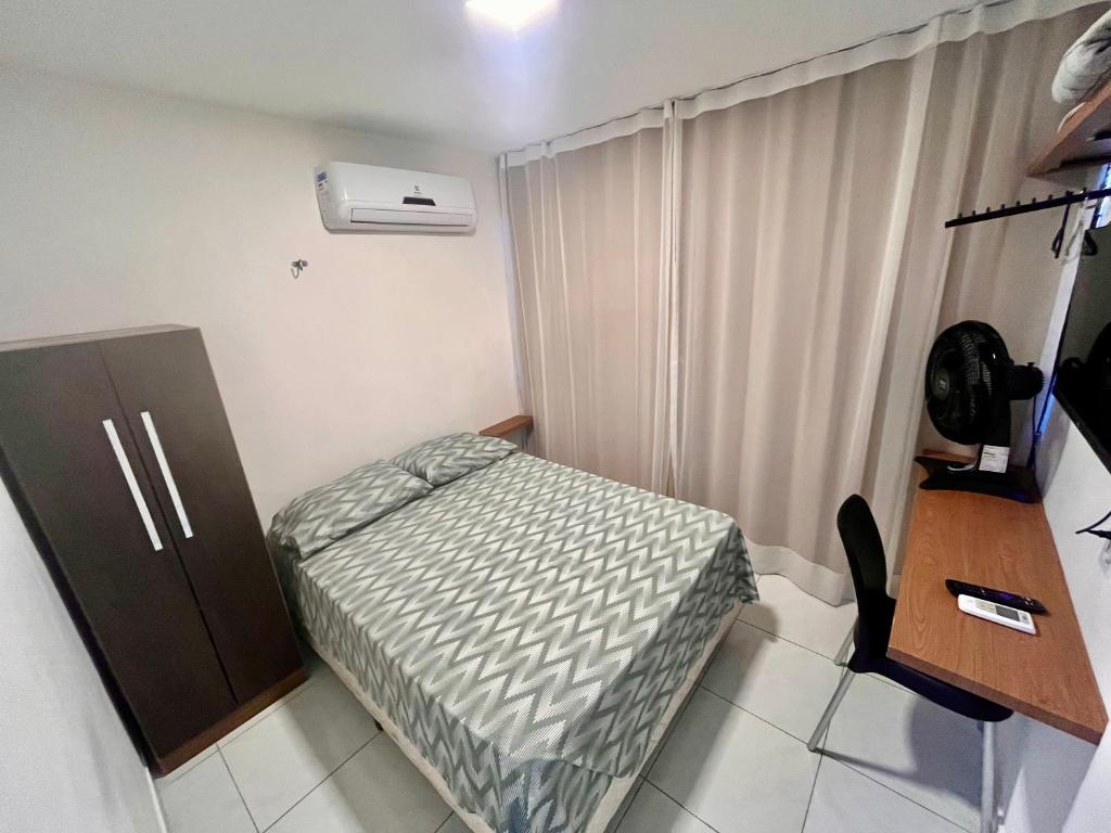 a small room with a bed and a desk at Charme 210 in Natal