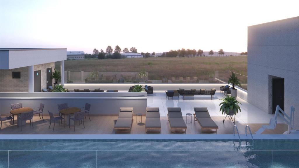 a swimming pool with chairs and tables on a patio at Hampton By Hilton Caraguatatuba Serramar in Caraguatatuba