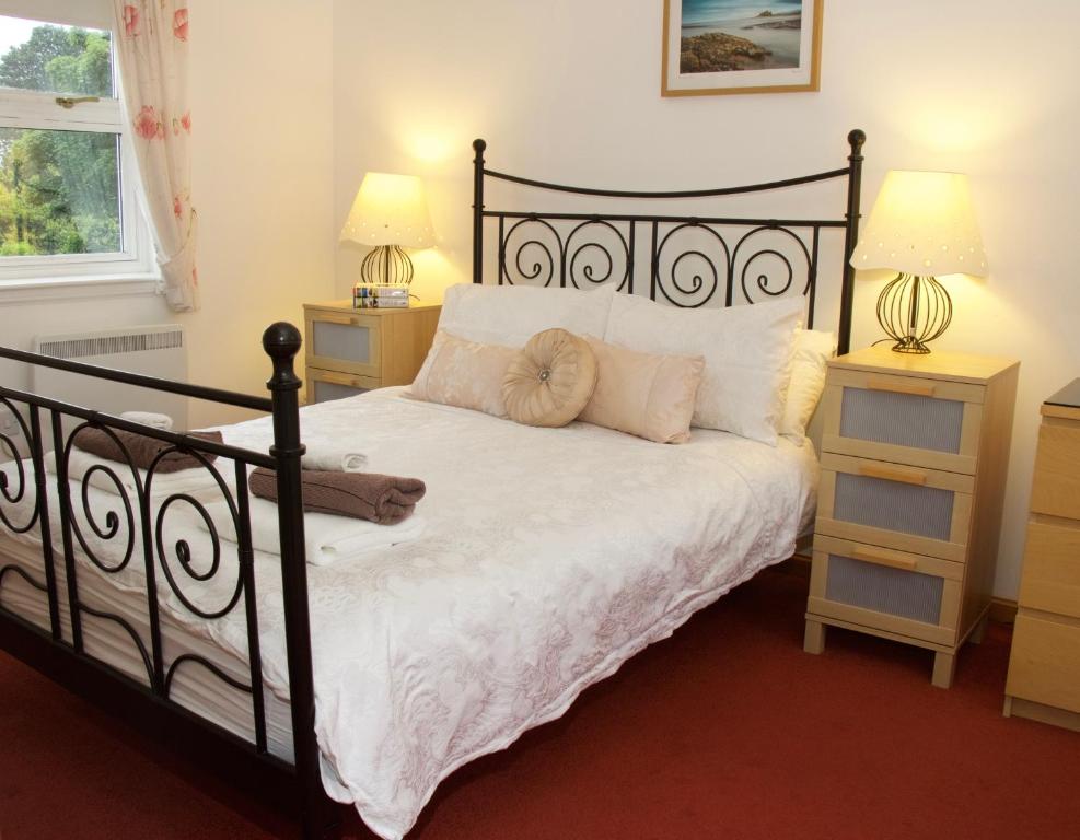 a bedroom with a black bed with two night stands at Pintail Apartment Bamburgh in Bamburgh