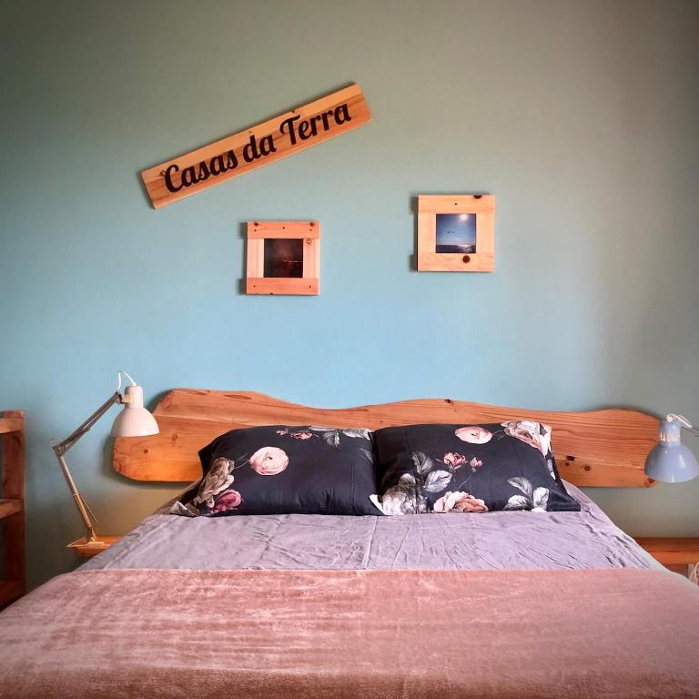 a bedroom with a bed with a sign on the wall at Casa Malagueta in Lajes das Flores