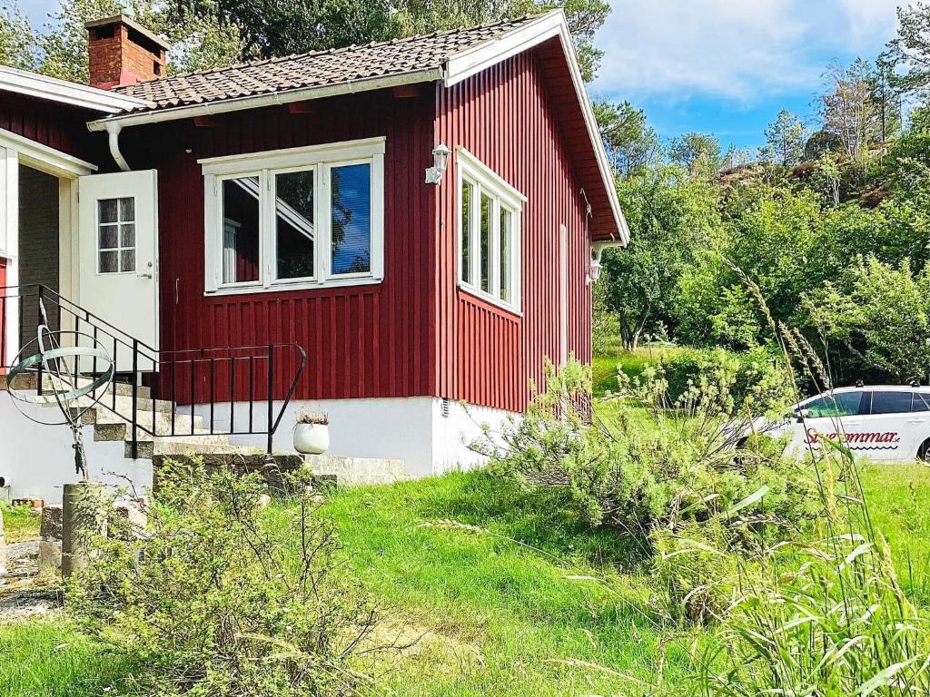 a red and white house with a car parked next to it at 4 person holiday home in UDDEVALLA in Uddevalla