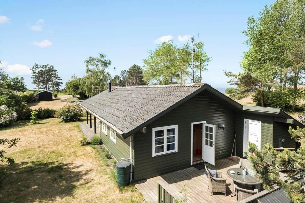 a black tiny house with a deck and a table at K19047-Kalundborg-Charlesvej-8 in Kalundborg