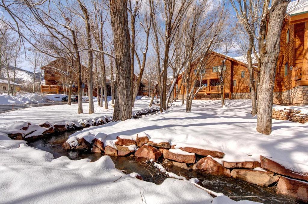 a stone wall in the snow next to a house at KBM Resorts Timber Wolf Lodge Mountain Elegance with Gas Fireplace Common Hot Tubs Near Canyons Village TWL-5b in Park City