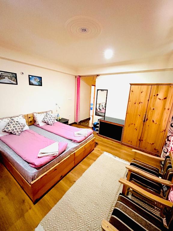 a bedroom with two beds and a rug at The Puma house in Leh