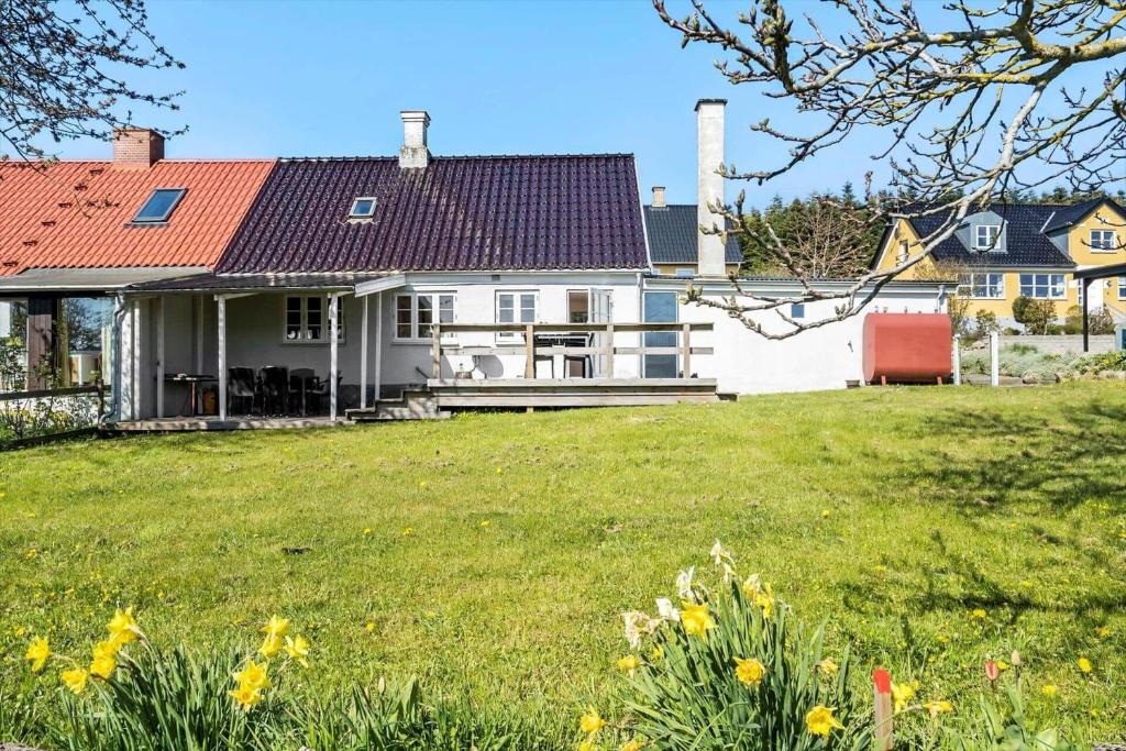 a white house with a red roof and a yard at 20203-Samso-Vrangstrup-5 in Tanderup