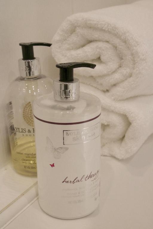 a white bottle of soap next to a towel at Pintail Apartment Bamburgh in Bamburgh