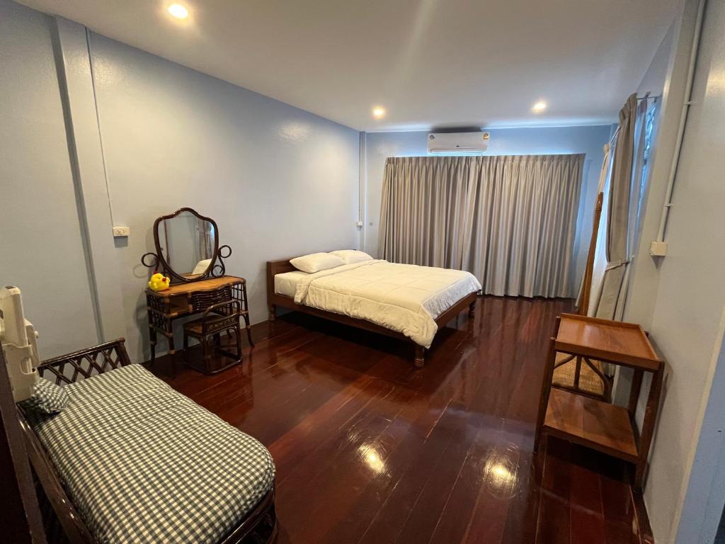 a room with two beds and a tv in it at Saen Saran property in Sathani Bang Ramat