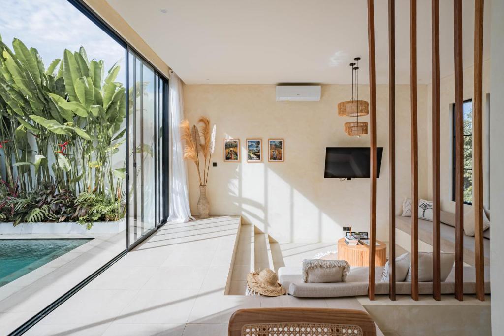 a living room with a pool and sliding glass doors at Lucky Villa 1 in Uluwatu