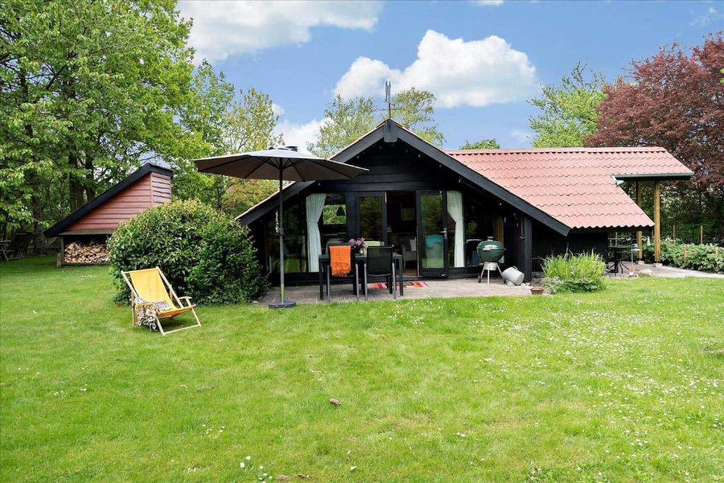 a house with an umbrella in the grass at 20114-Samso-Blamejsevej-9 in Nordby