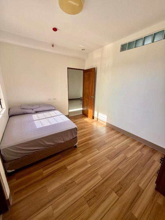 a bedroom with a bed and a wooden floor at Lheaf Residences and Serviced Apartments in Cebu City