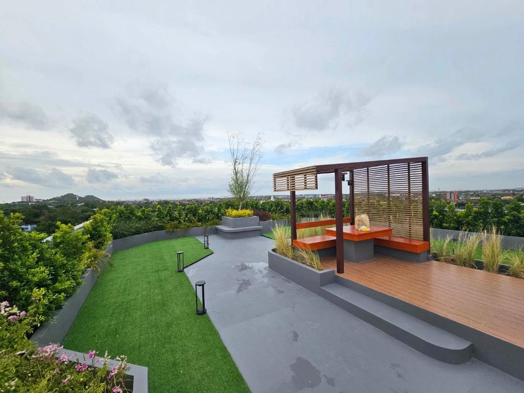 a garden with a wooden deck and a lawn at คอนโดอีสวิลบางแสน ห้อง 7 in Ban Hua Khao Sammuk