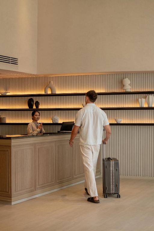 A reception desk backed by illuminated display shelving and decorative objects.