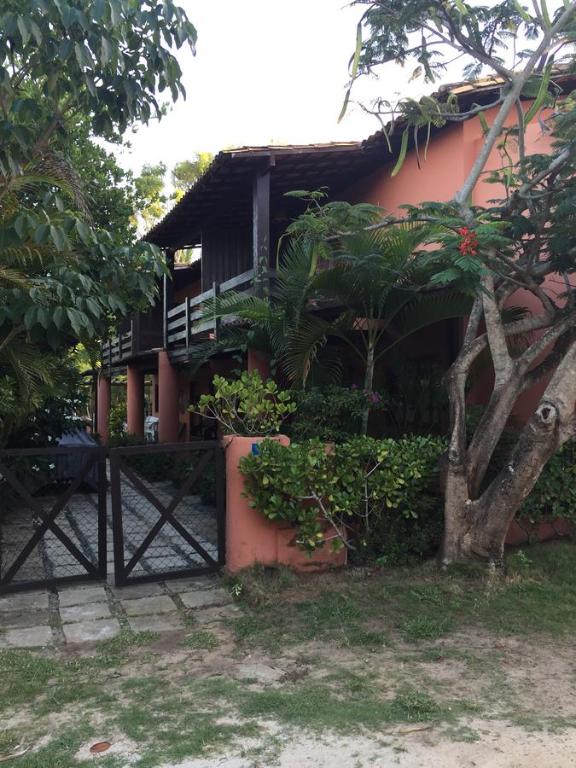 a house with a tree in front of it at Apartamentos Aconchegantes, Villa da Praia in Praia do Forte