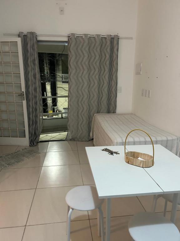 a room with a bed and a table and chairs at Estadia Luz & Fé in Cachoeira Paulista