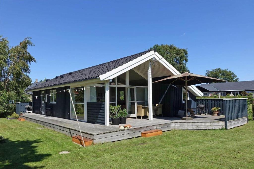 a blue house with a large deck in a yard at 20409-Samso-Nylandsvej-21-A in Ballen