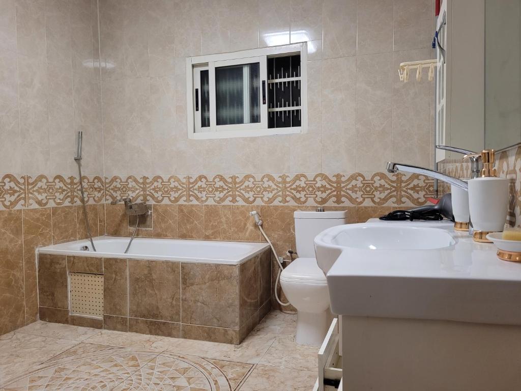 Un baño con bañera, inodoro y lavabo. en Sheyllo Suites Abidjan - Cocody, en Abiyán