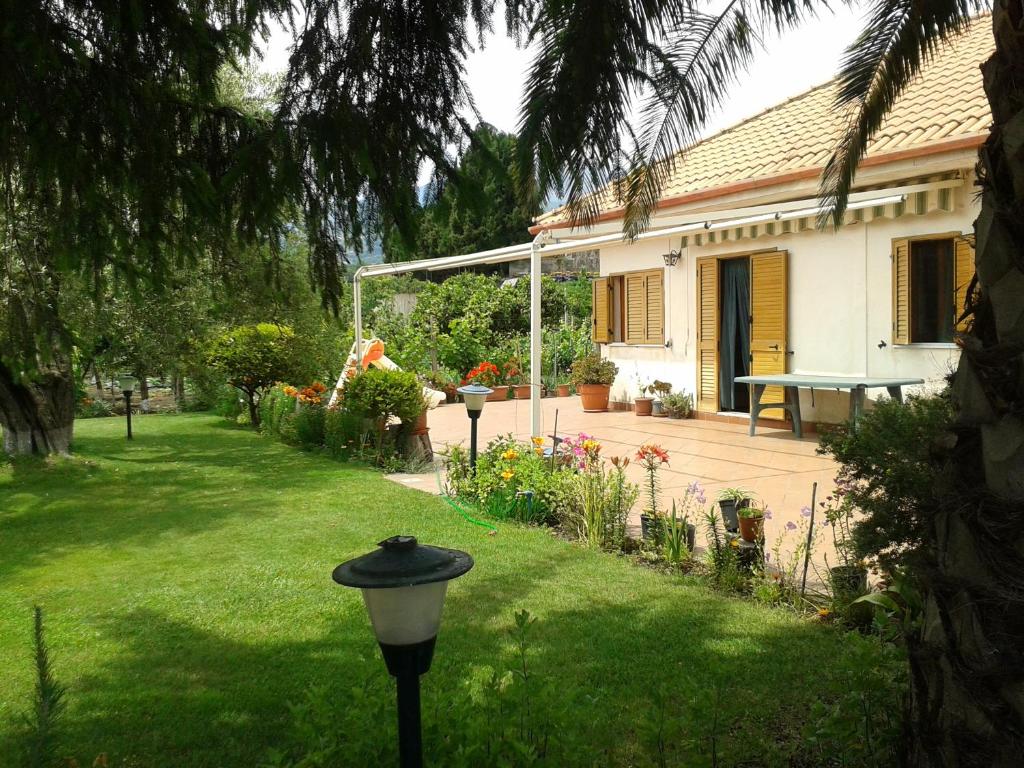 a garden with a house and a lamp in the grass at Villa Etna in Piedimonte Etneo