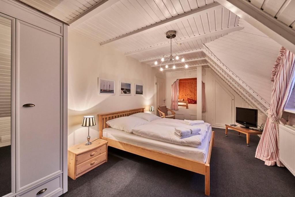 a bedroom with a bed and a television in it at Dünengras in Cuxhaven
