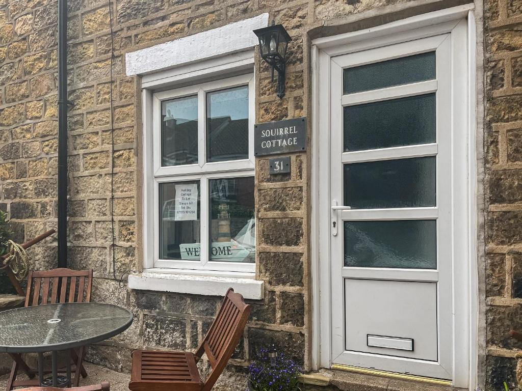 a table and chairs outside of a building with a window at Squirrel Cottage in Filey