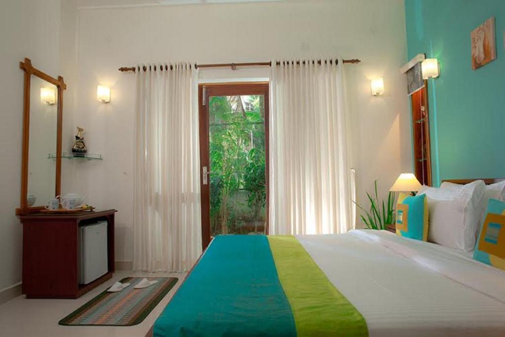 a bedroom with a large bed and a window at The Francis Residence in Cochin