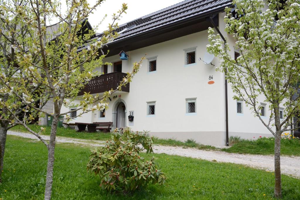 een wit gebouw met bomen ervoor bij Apartment Zatrnik in Bled