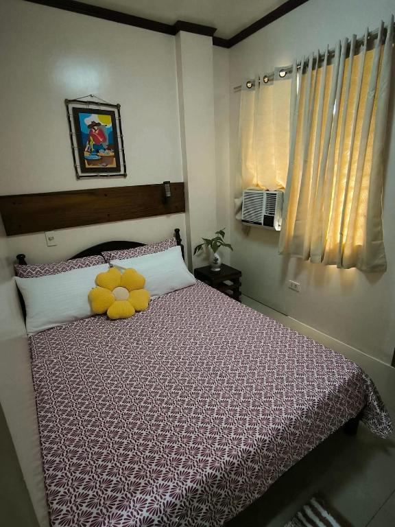 a bedroom with a bed with a teddy bear on it at ELNIDO BUDGET INN SILVERISE Pension in El Nido