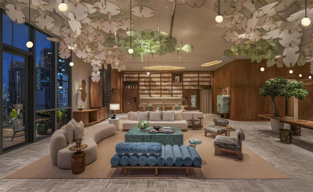 A styled hotel living room combines sofas, lounge chairs, and a built-in library.