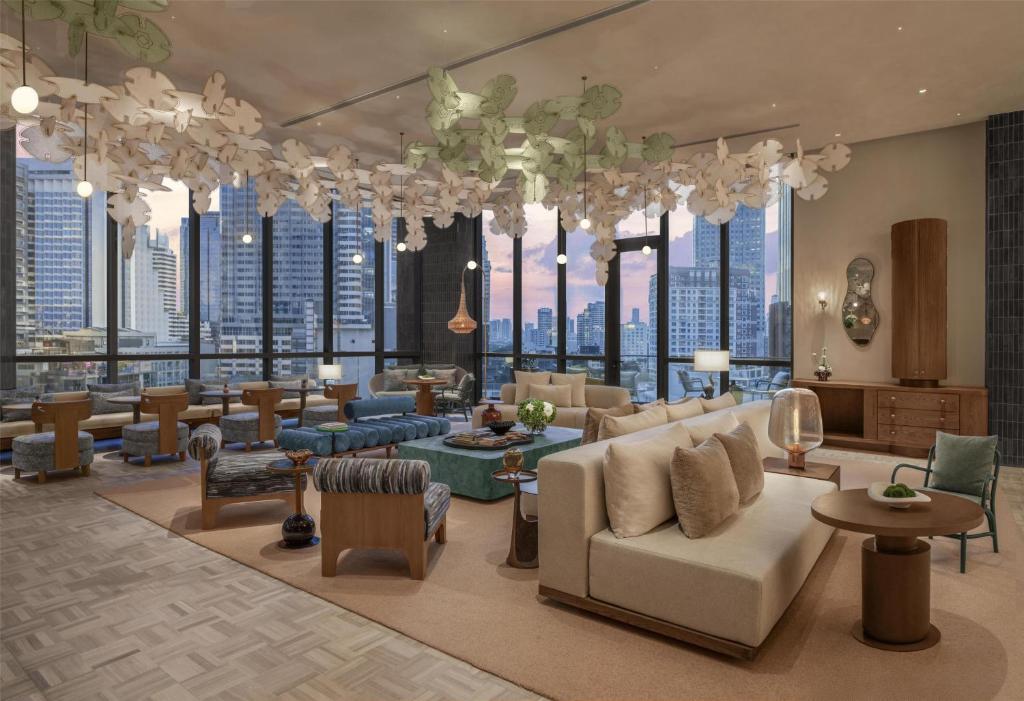 A spacious lounge overlooks Bangkok through floor-to-ceiling windows.