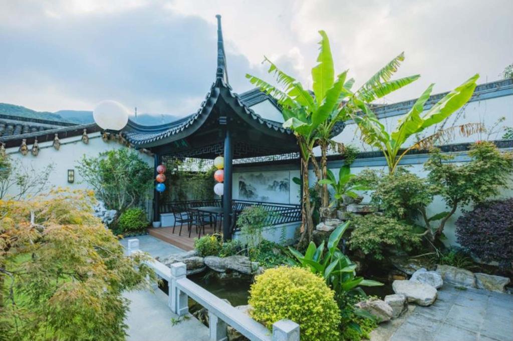 a house with a pond in a garden at Songlan Tea House · Shanhai Resort Chinese style Courtyard Villa in Xiangshan