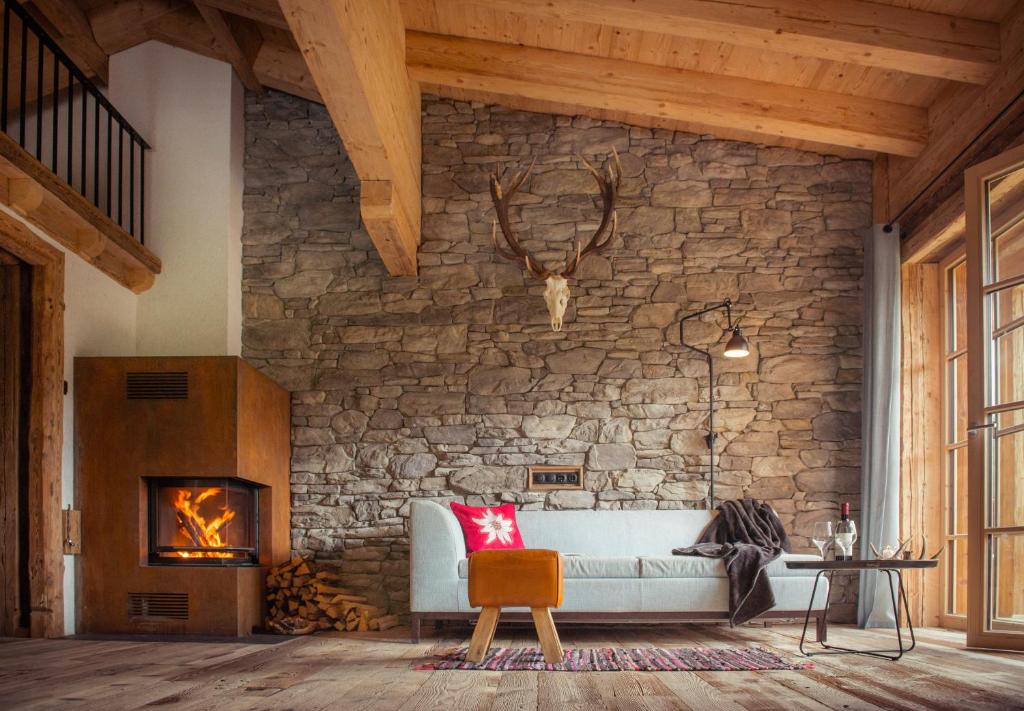 sala de estar con sofá y chimenea en Kasermandl, en Elbigenalp