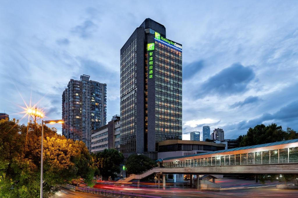 a tall building with a sign on it in a city at Holiday Inn Express Guiyang Downtown by IHG in Guiyang