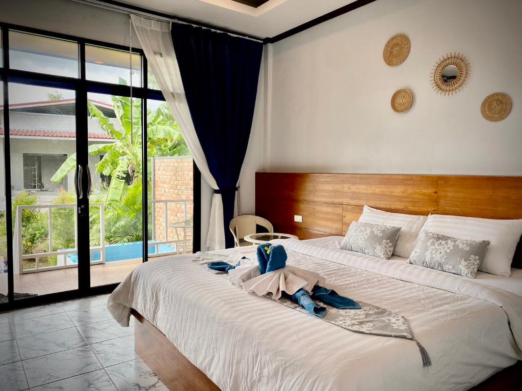 a bedroom with a large bed with towels on it at AMORA Lanta in Ko Lanta Yai