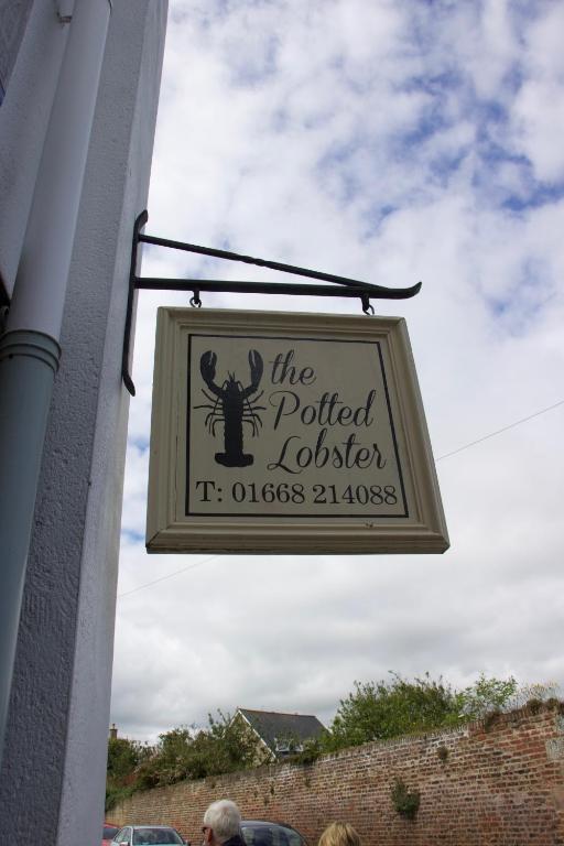 a sign for the prettier lobster hanging on a building at Pintail Apartment Bamburgh in Bamburgh