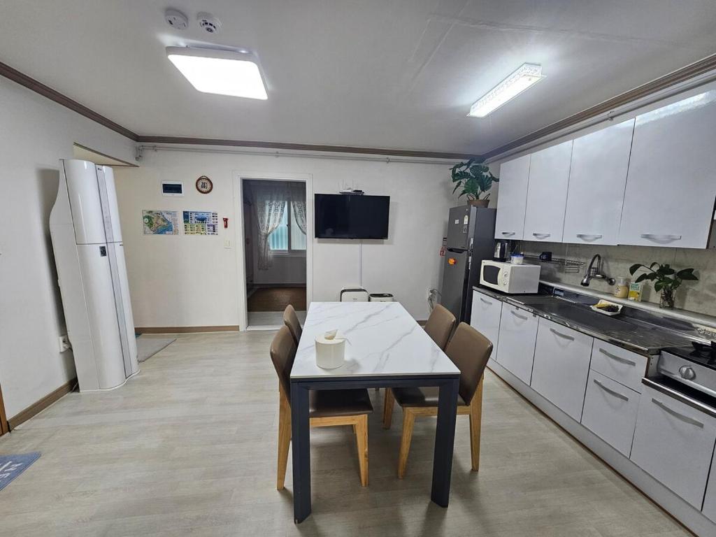 a kitchen with a table and chairs in a room at Gwangalli Tahee House in Busan